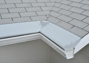 Tan roof with white gutters and gutter guards