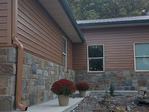Home with new, steel siding and potted plants in front
